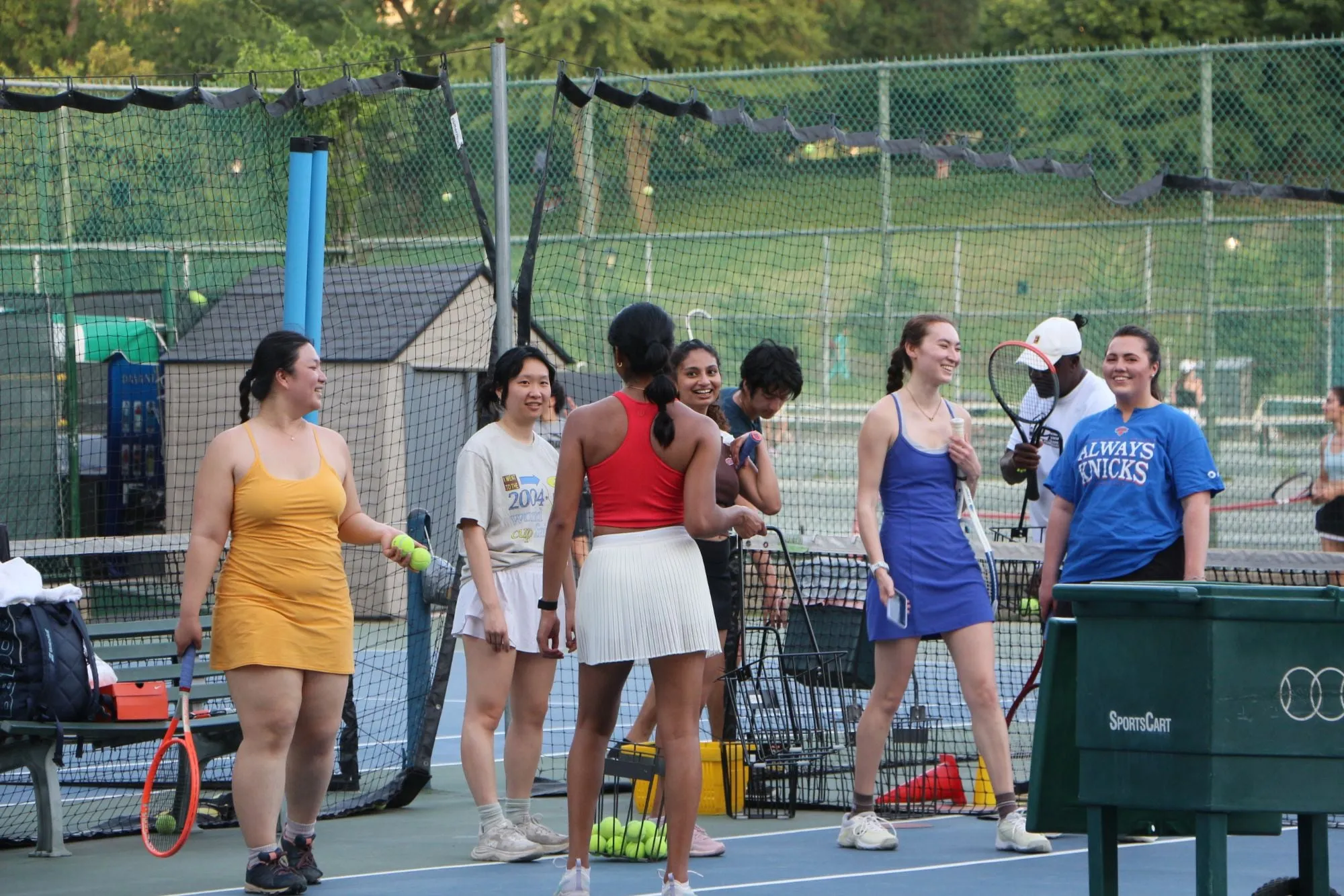 friends with rackets laughing together on a tennis court